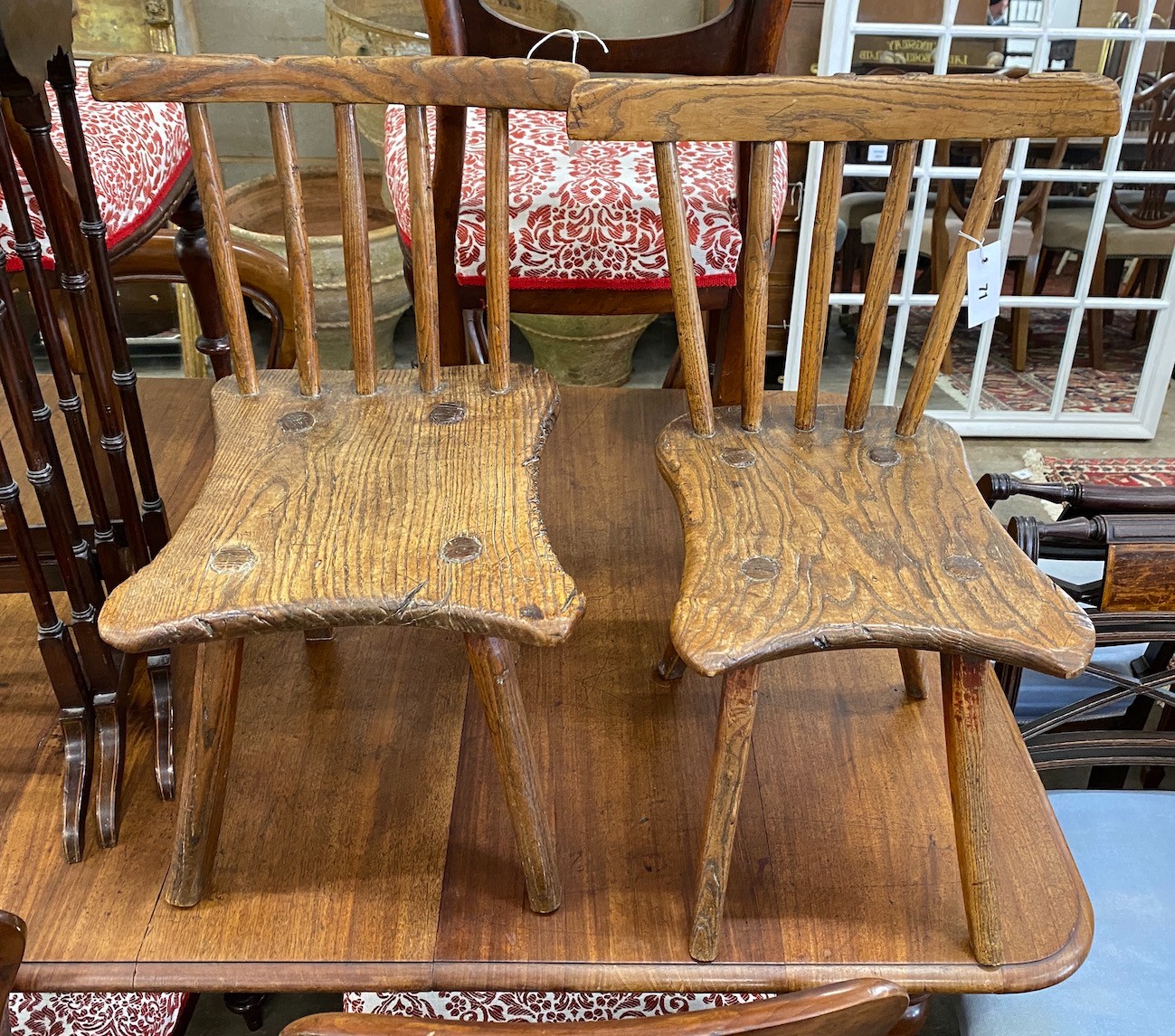 A near pair of 19th century primitive ash and elm Windsor child's chairs, larger width 34cm, depth 39cm, height 63cm